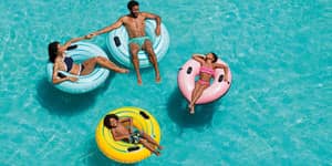 Four Friends floating on tubes in pool