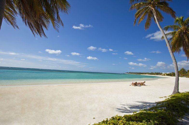 Two people lounging next to beach