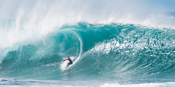 Person surfing through Banzai Pipeline