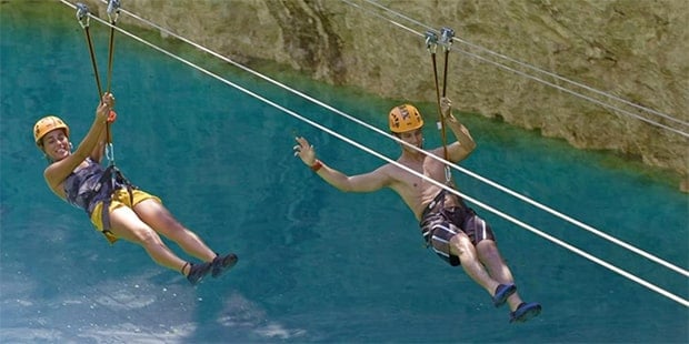 Couple on zipline above water