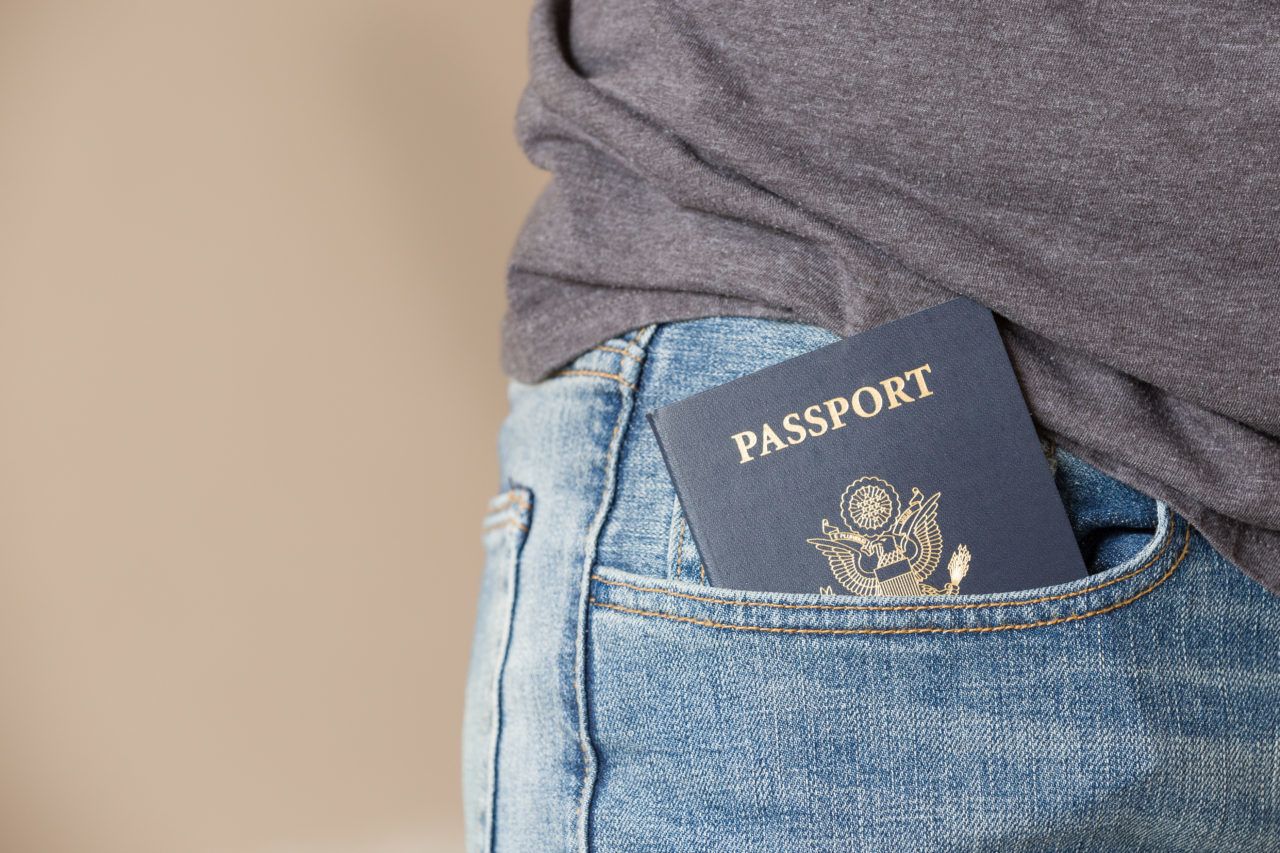 Closeup of US passport in man's jeans pocket.