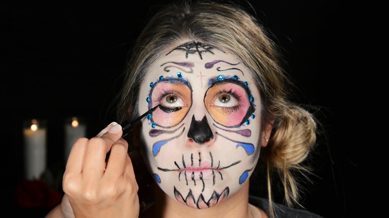 Eyeliner and rhinestone application, Day of the Dead face painting