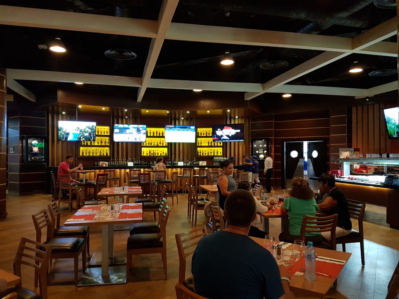 Bar area with TVs and people at tables