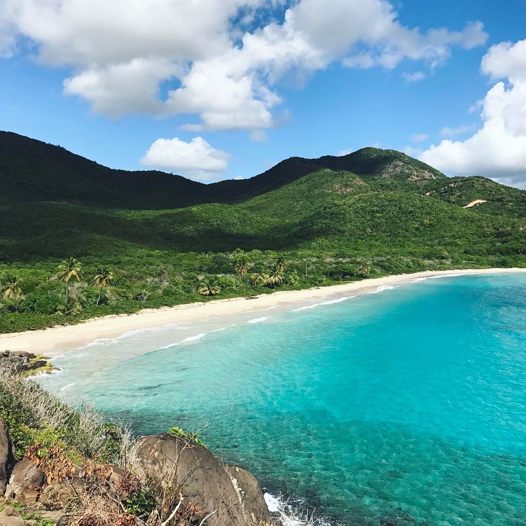 Hidden beach view with rolling mountains behind it. 