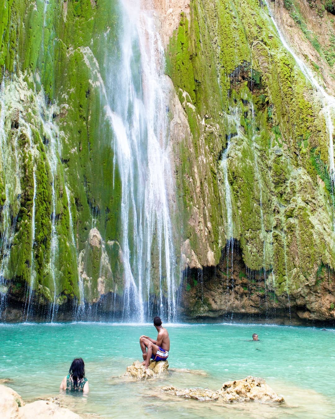 View of the falls with people in pool below