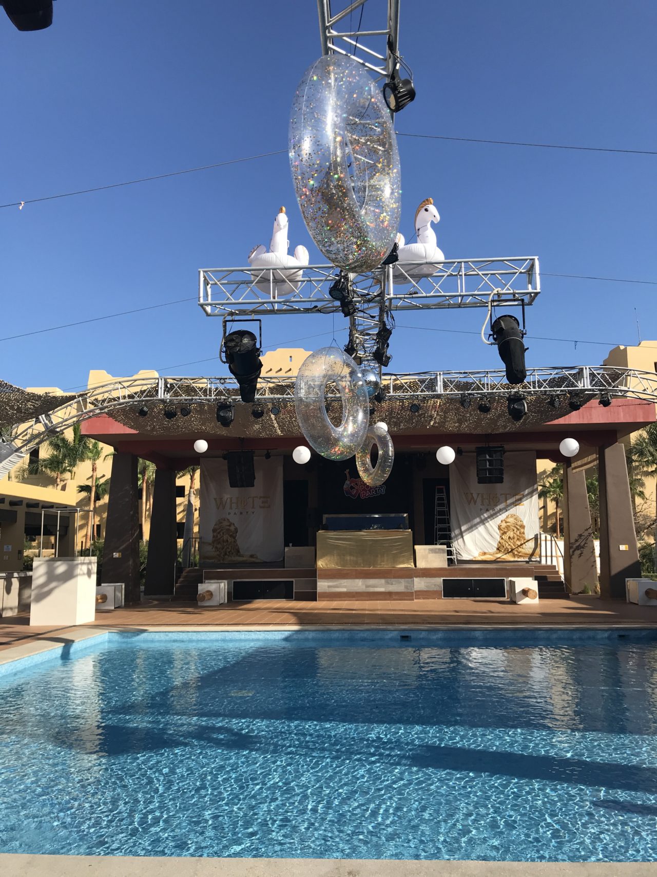 Pool during the day with floats and stage. 