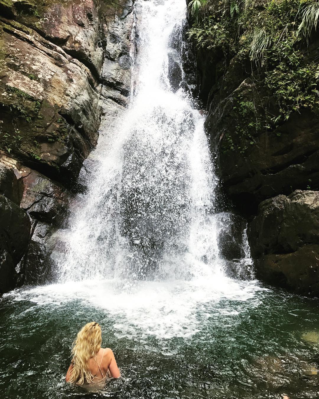 Woman at the bottom of waterfall