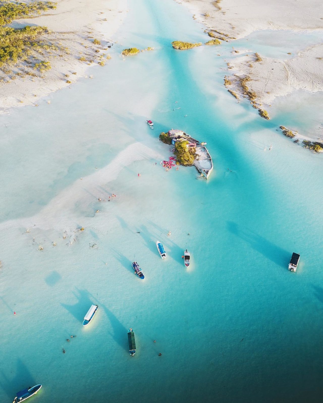 Aerial view of lagoon with boats in water. 