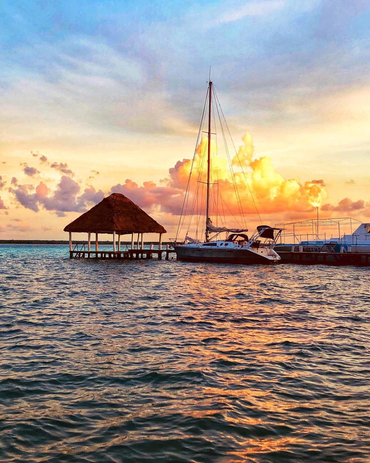 Sunset view with sailboat over water. 