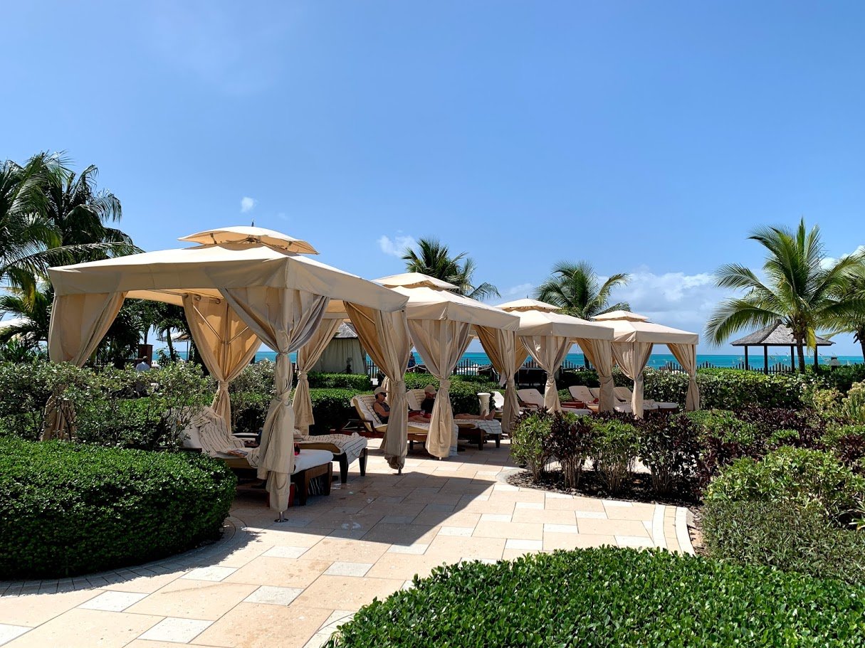 Poolside cabanas on the sidewalk. 