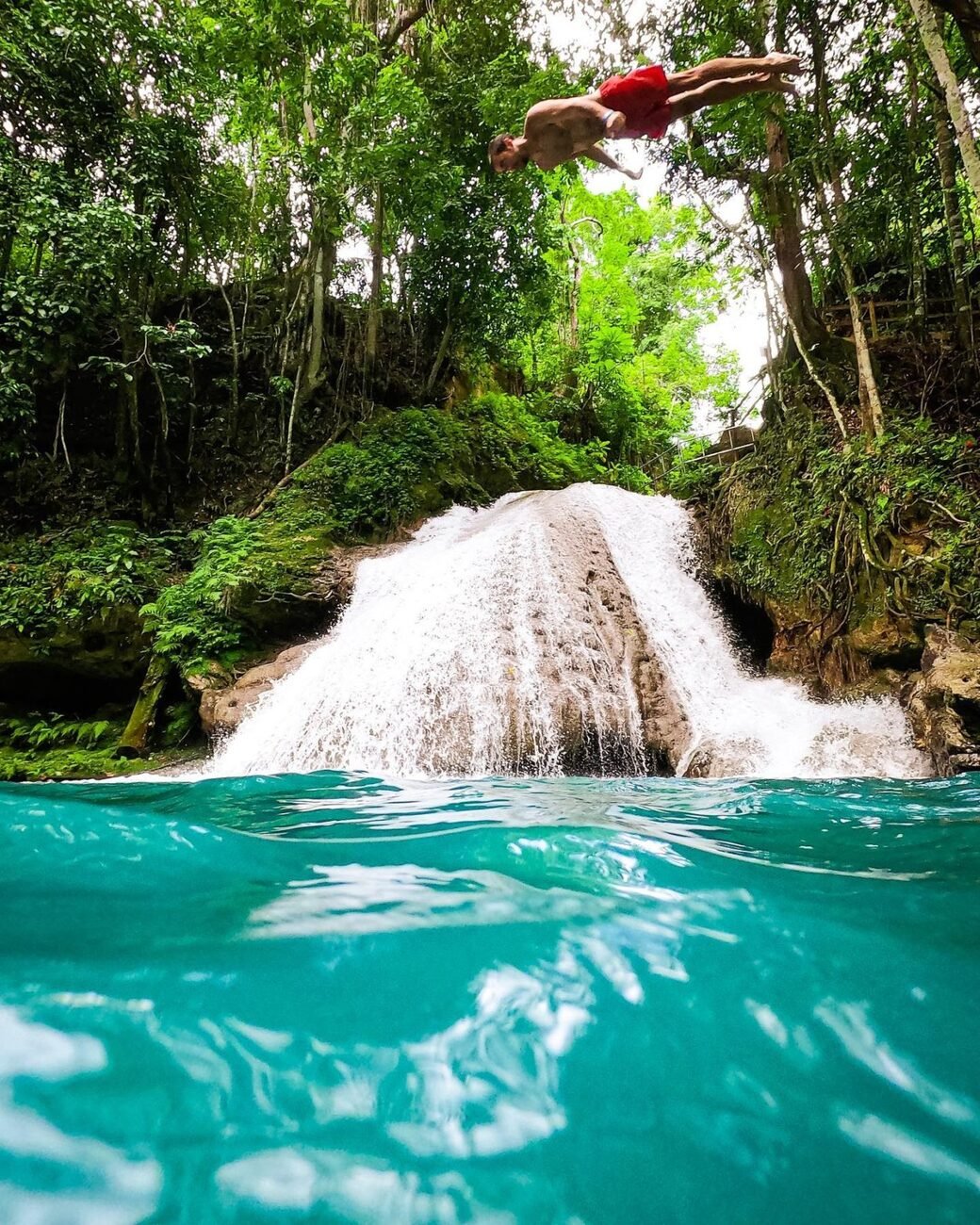 Guy jumping in blue hole in Jamaica.