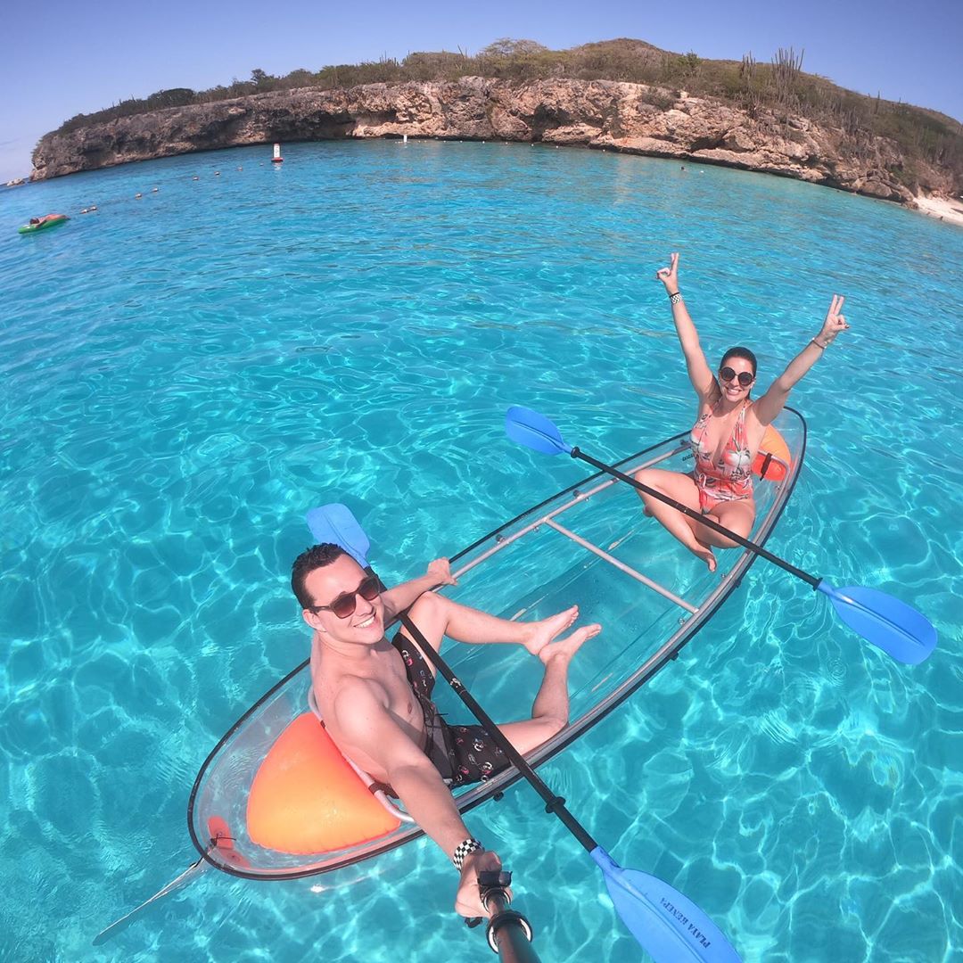 Couple on transparent kayak in the ocean of Playa Kenepa.