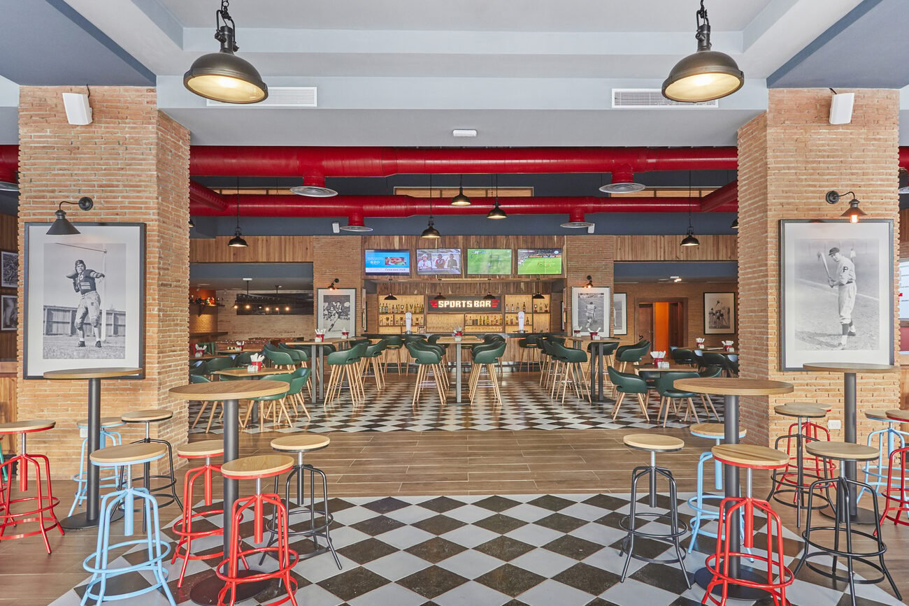 View of sports bar with tables and TVs.