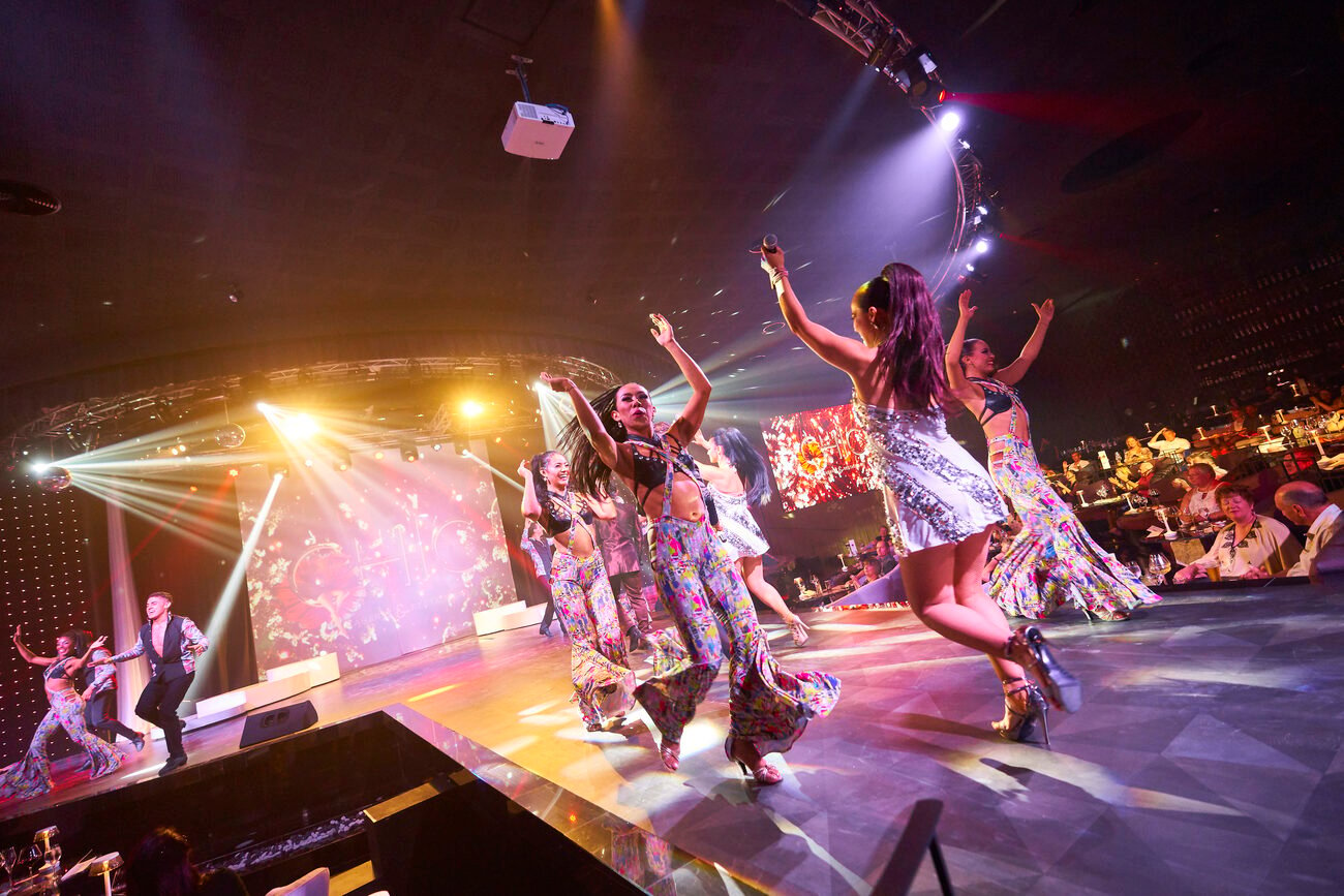 Girls running around on stage with lights in background.