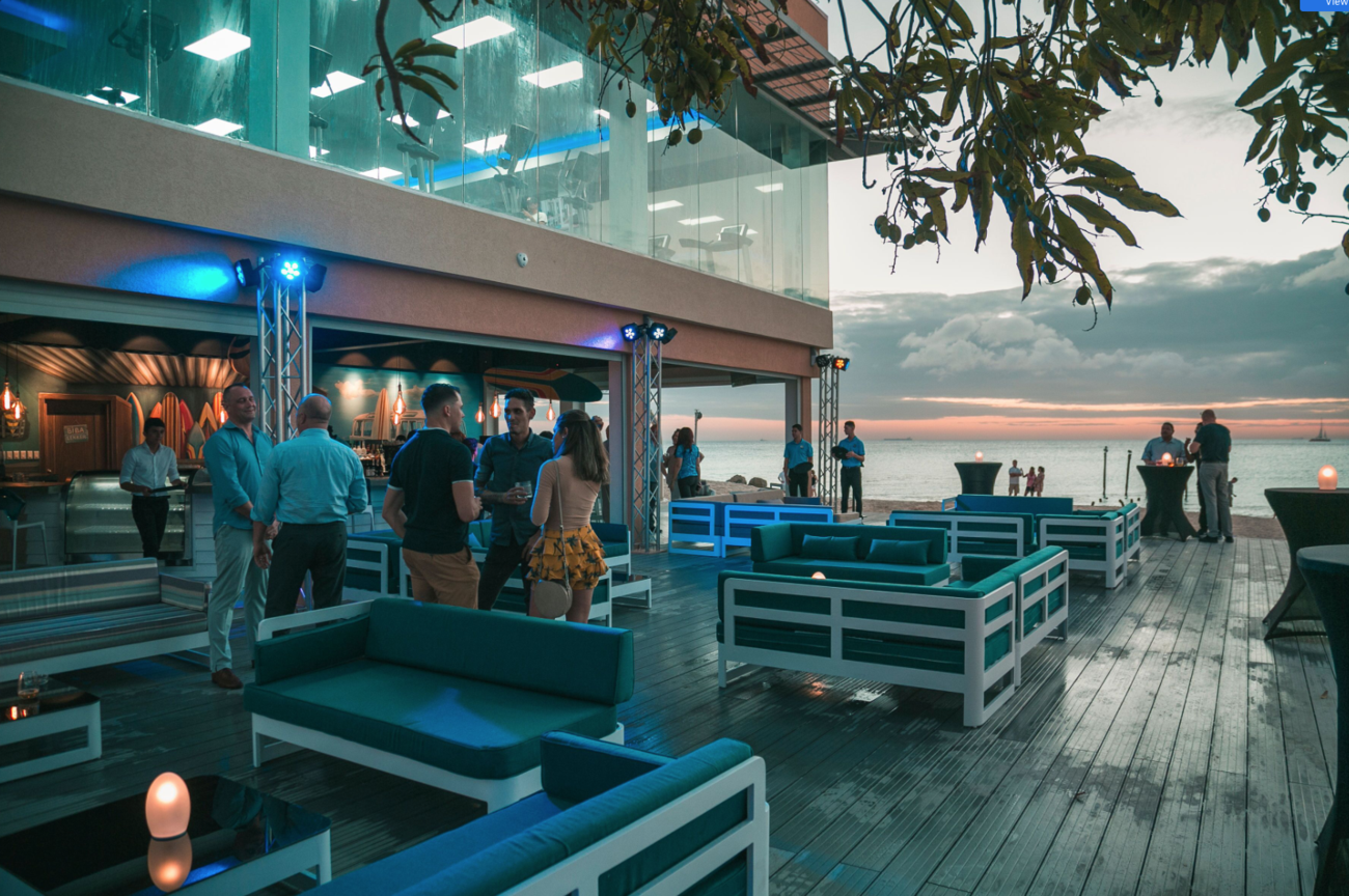 People at outside bar with ocean view.