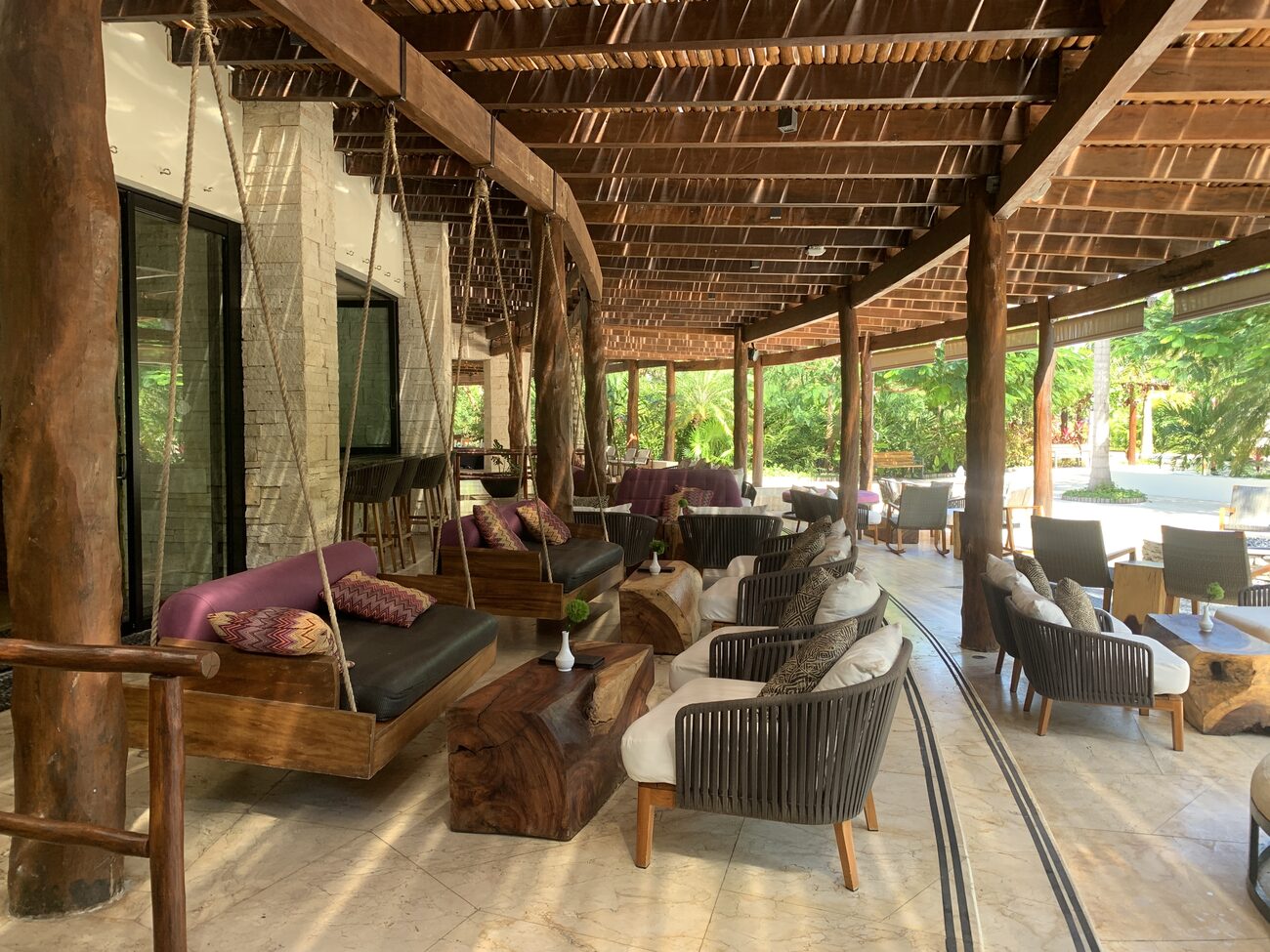 Patio area outside with hanging chairs.