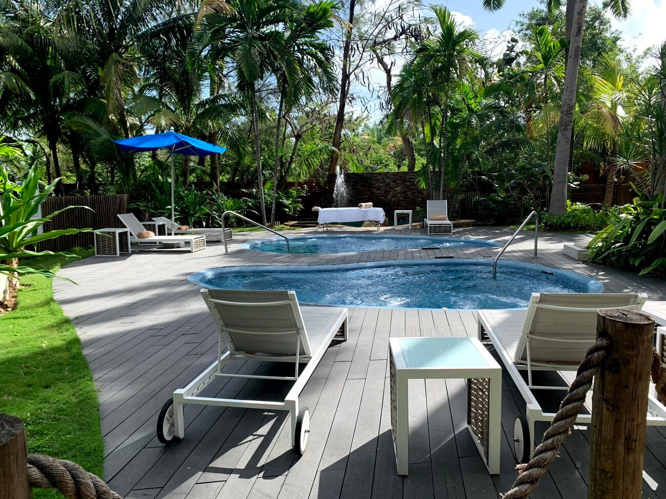 Outdoor spa with chairs and massage table.